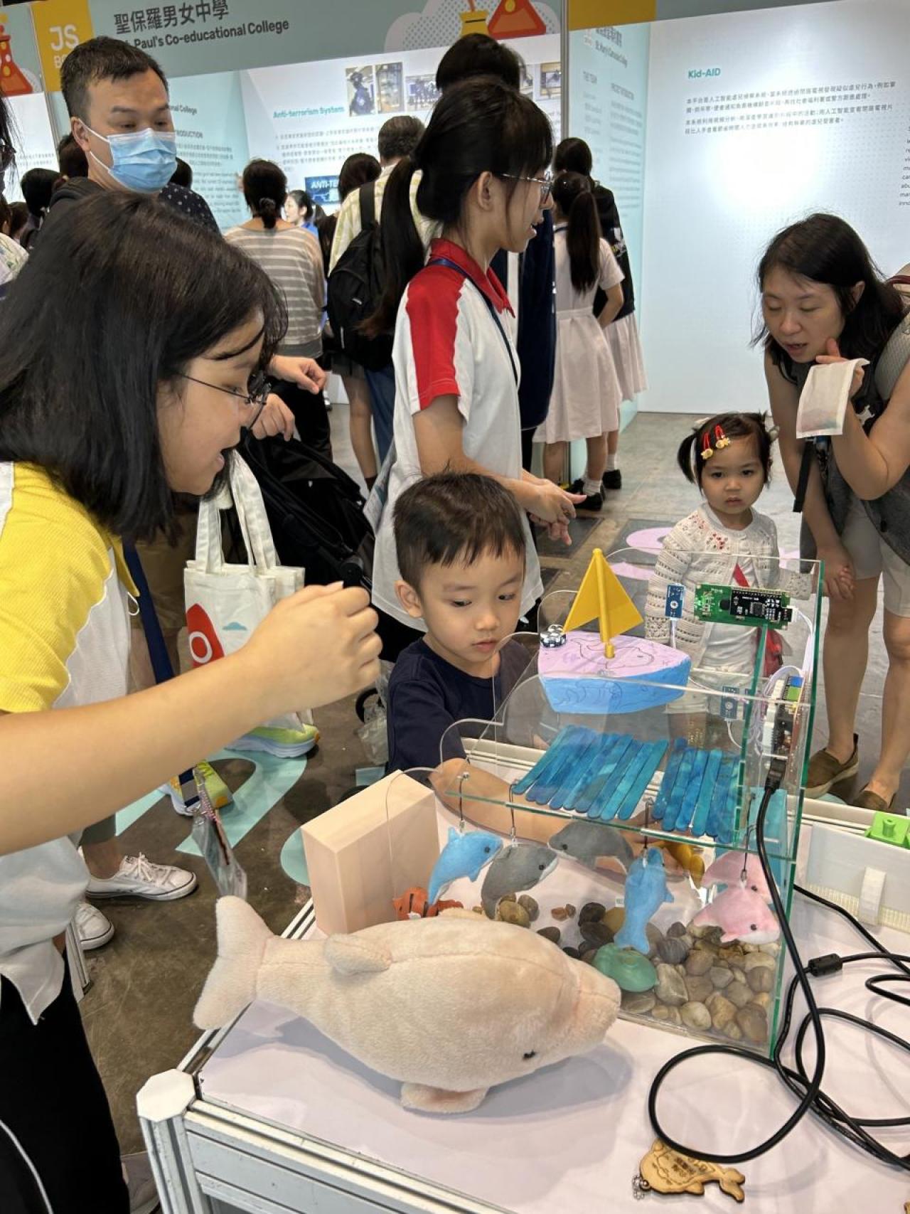 同學的作品吸引了不少小朋友的注意力，他們都專心聆聽3A劉子晴同學的解說。